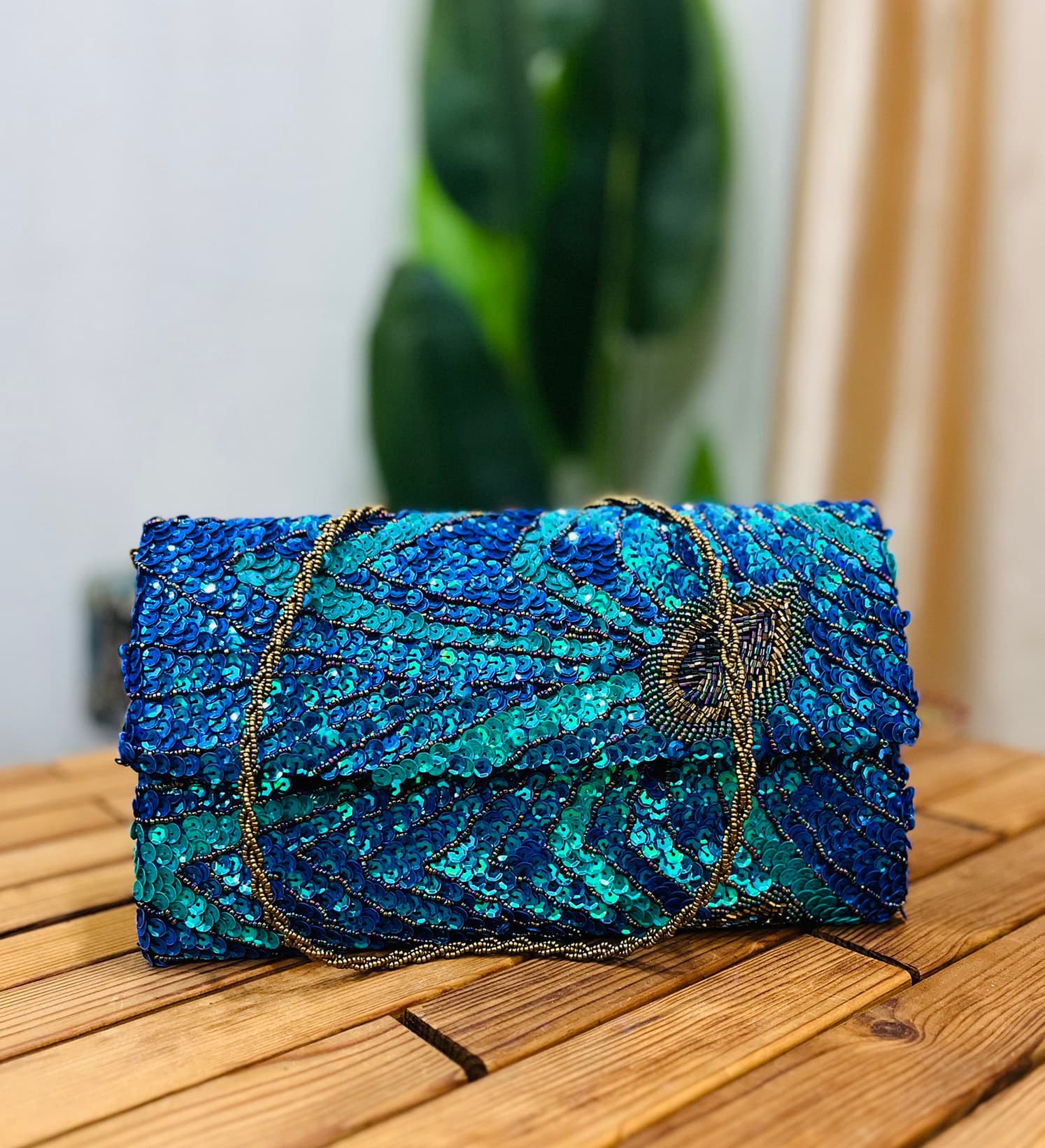 Handcrafted envelope clutch featuring a peacock feather design with sequins and beads, on a textured fabric by Zara Label.