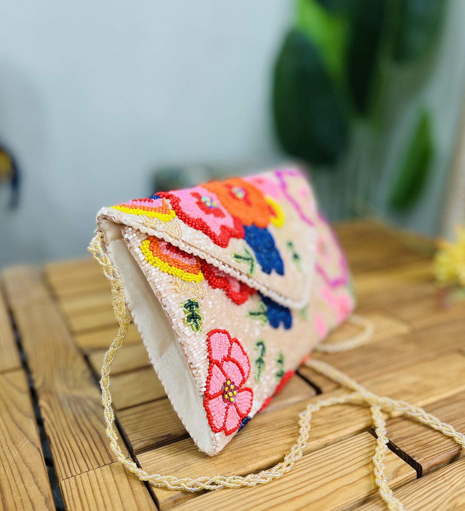 Colorful floral hand-beaded envelope clutch on a plain background, showcasing intricate detailing and vibrant design by Zara.