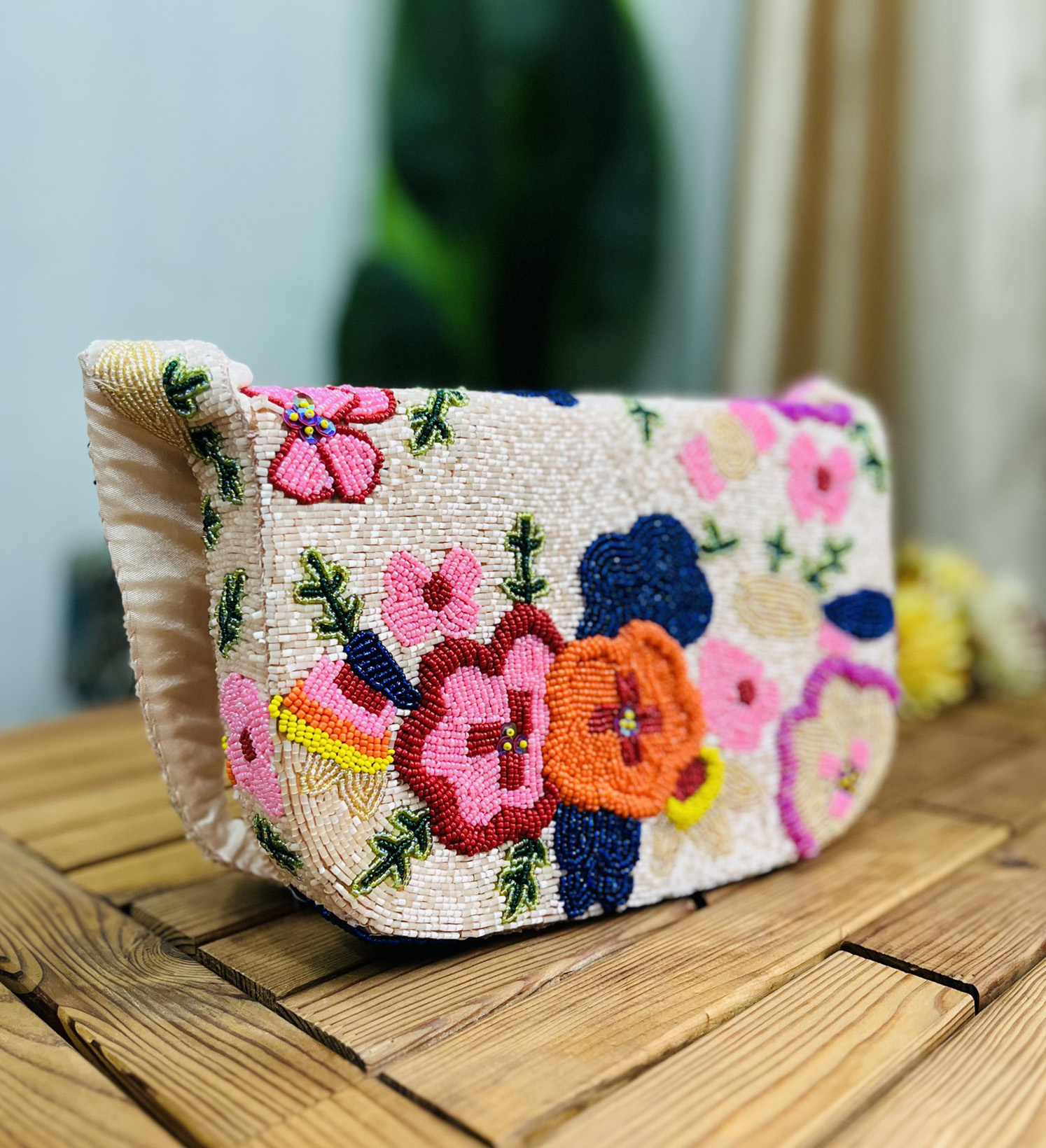 Colorful hand-beaded shoulder bag featuring vibrant floral patterns, set against a light background, showcasing Zara's
