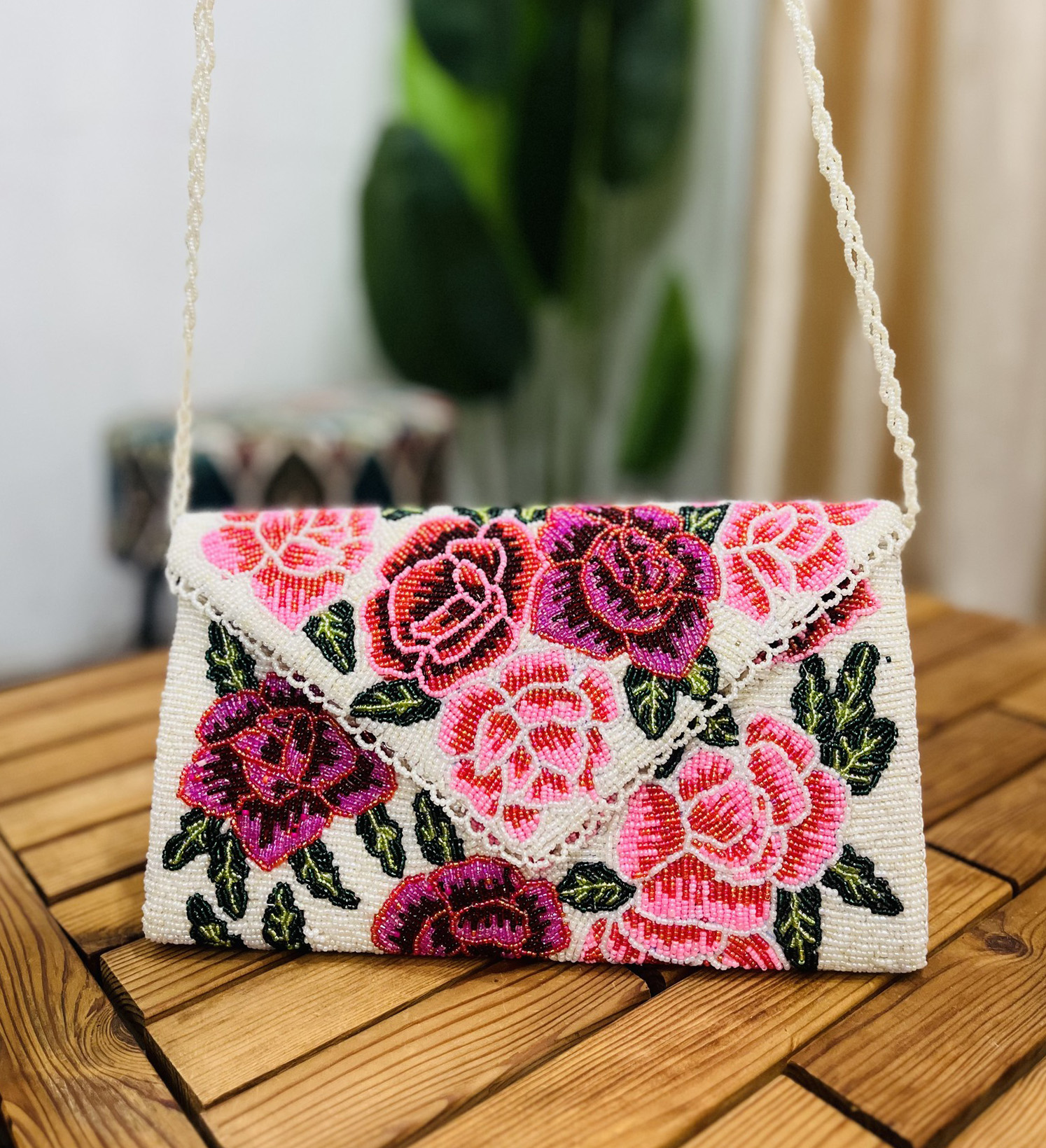 Hand-beaded envelope clutch with colorful rose patterns on a white background from Zara Label, featuring intricate