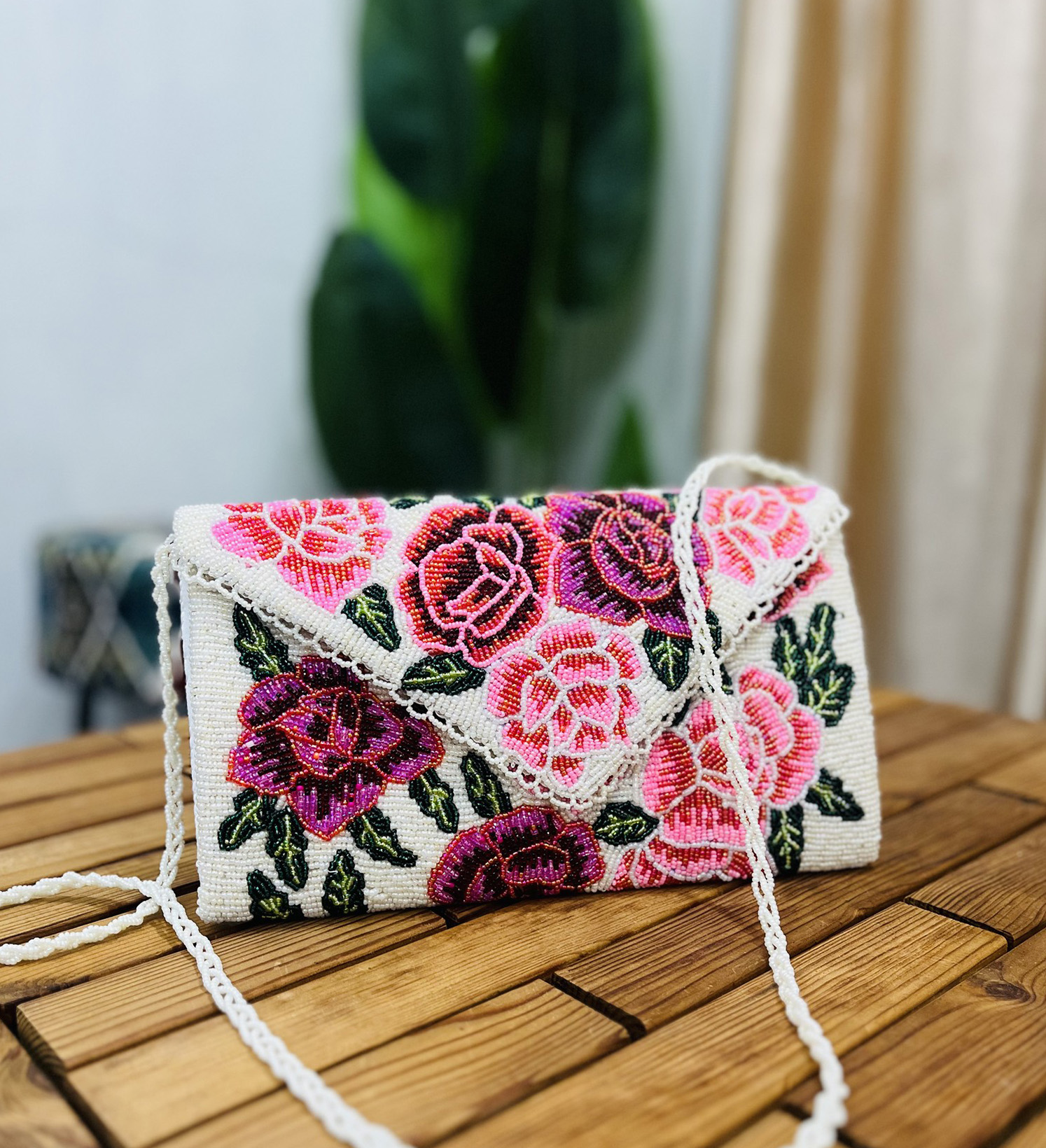 A vibrant envelope clutch adorned with intricate beaded floral rose patterns, showcasing the artisan craftsmanship of Zara