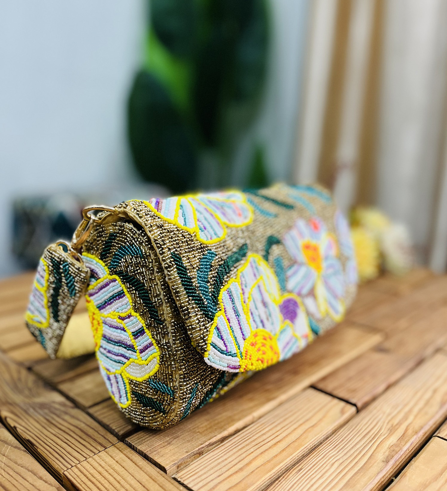 Gold beaded shoulder bag with intricate floral patterns, gold chain strap, and label tag. Perfect for a glamorous evening