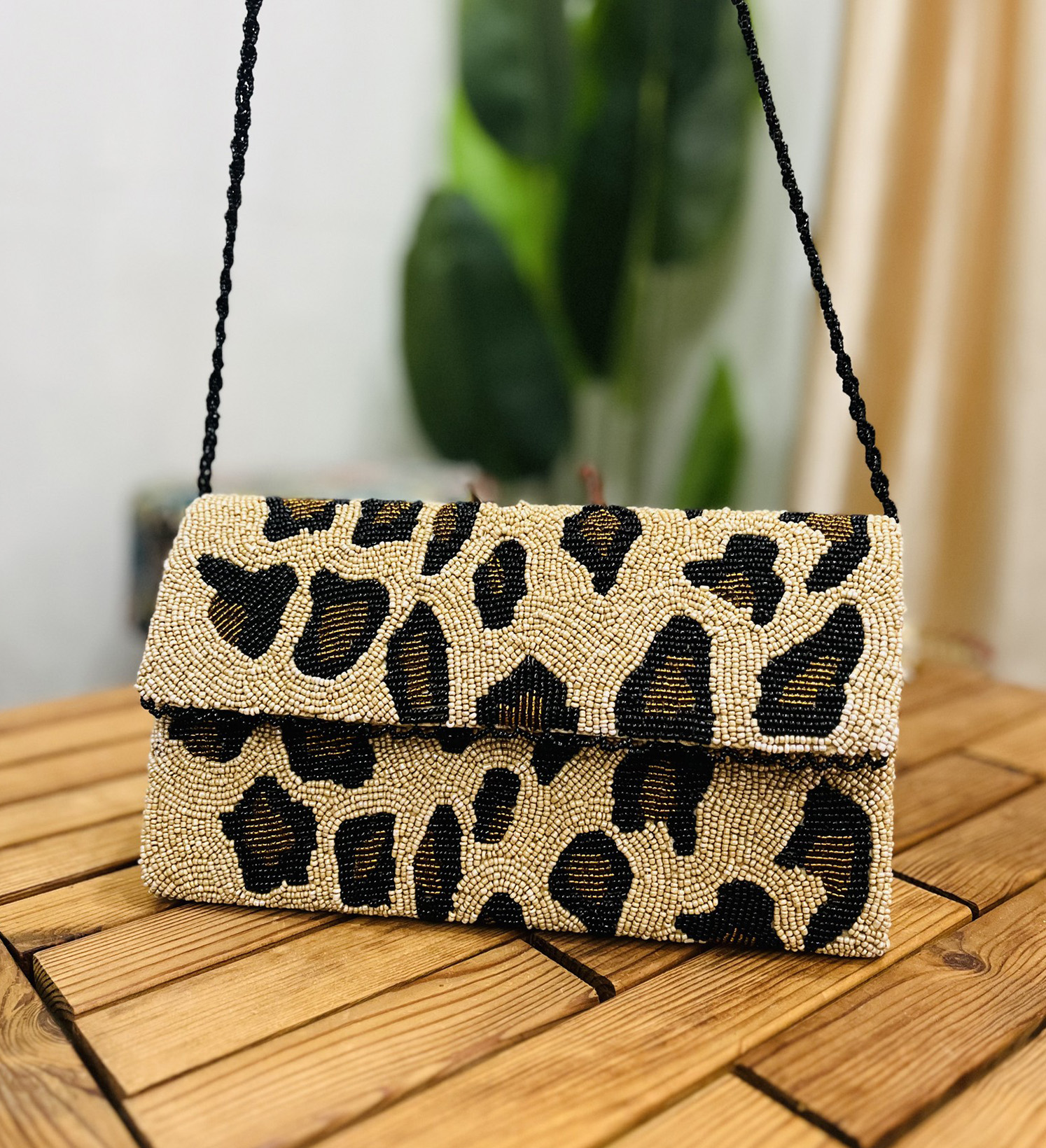 Leopard print envelope clutch with intricate hand-beaded details, showcasing Zara Label branding on front.