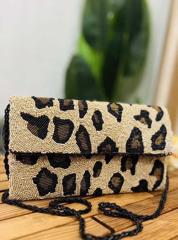 Artisan hand-beaded clutch with leopard print design, featuring a unique envelope shape and intricate bead detailing.