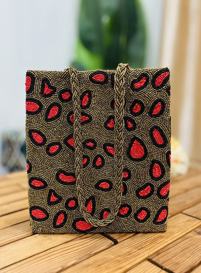 Leopard print tote bag with intricate hand-beaded detailing, featuring a mix of black, brown, and beige tones, crafted by