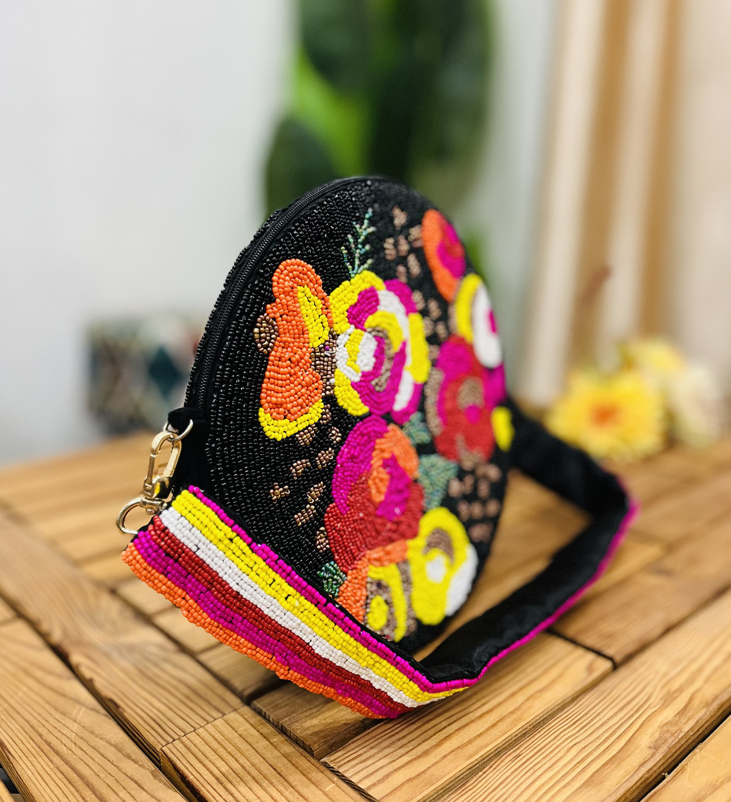 A round, hand-beaded shoulder bag with intricate black and white floral patterns against a dark background, by Zara Lab.