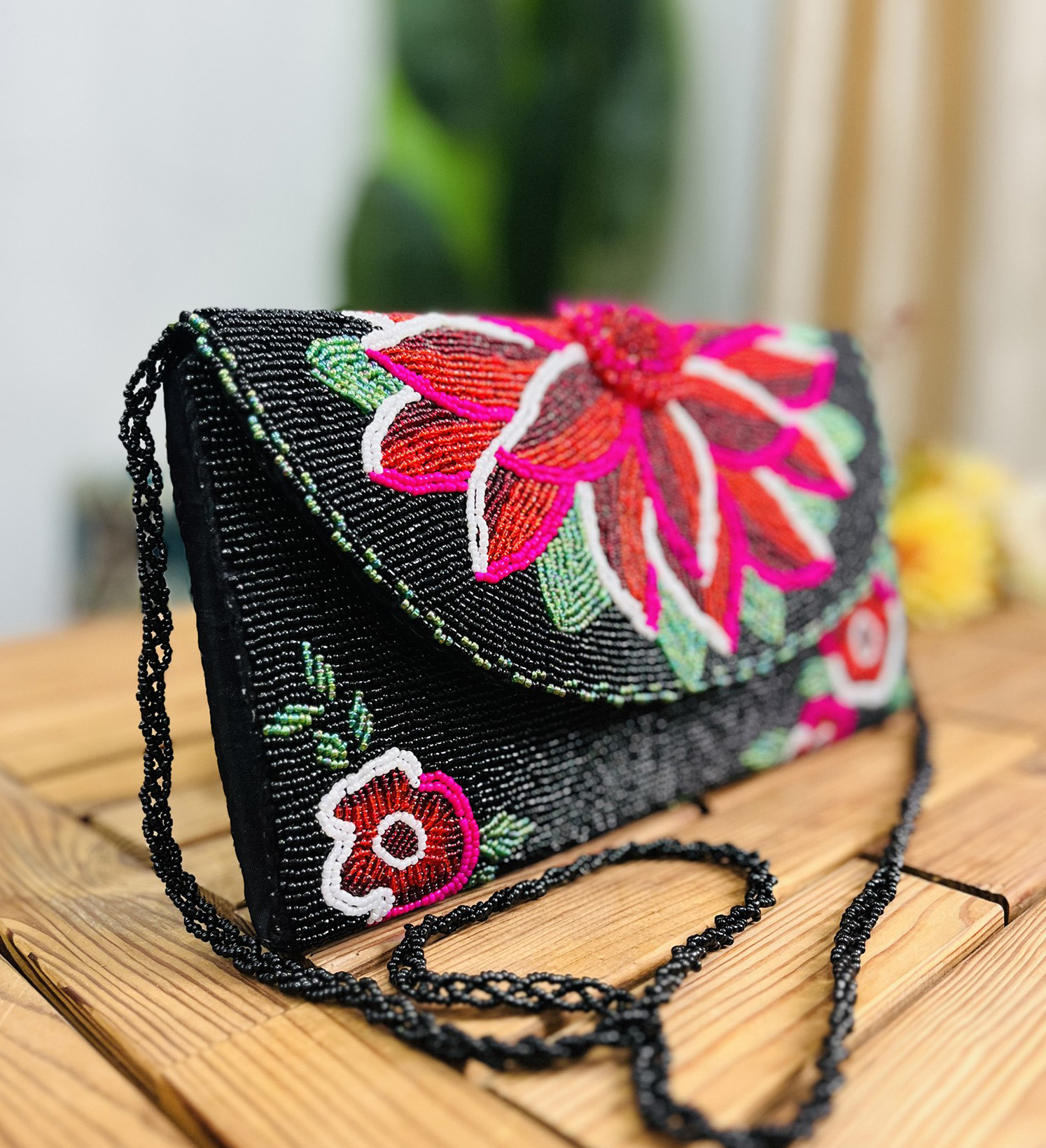 Midnight floral hand-beaded envelope clutch with intricate designs by Zara Label, showcasing vibrant colors on a black