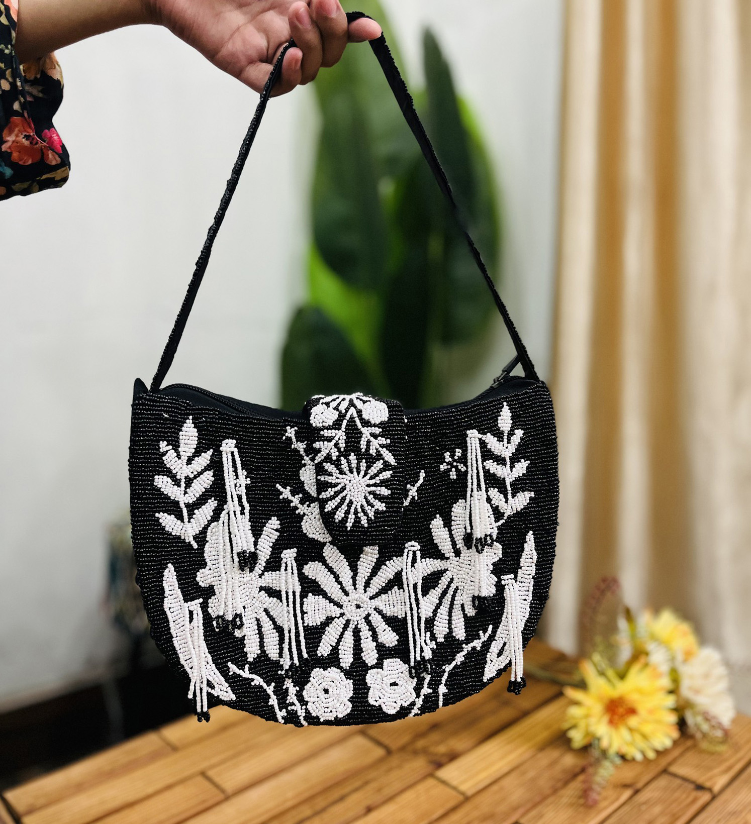 A monochrome floral hand-beaded shoulder bag with intricate beadwork, featuring a blend of dark and light floral patterns.
