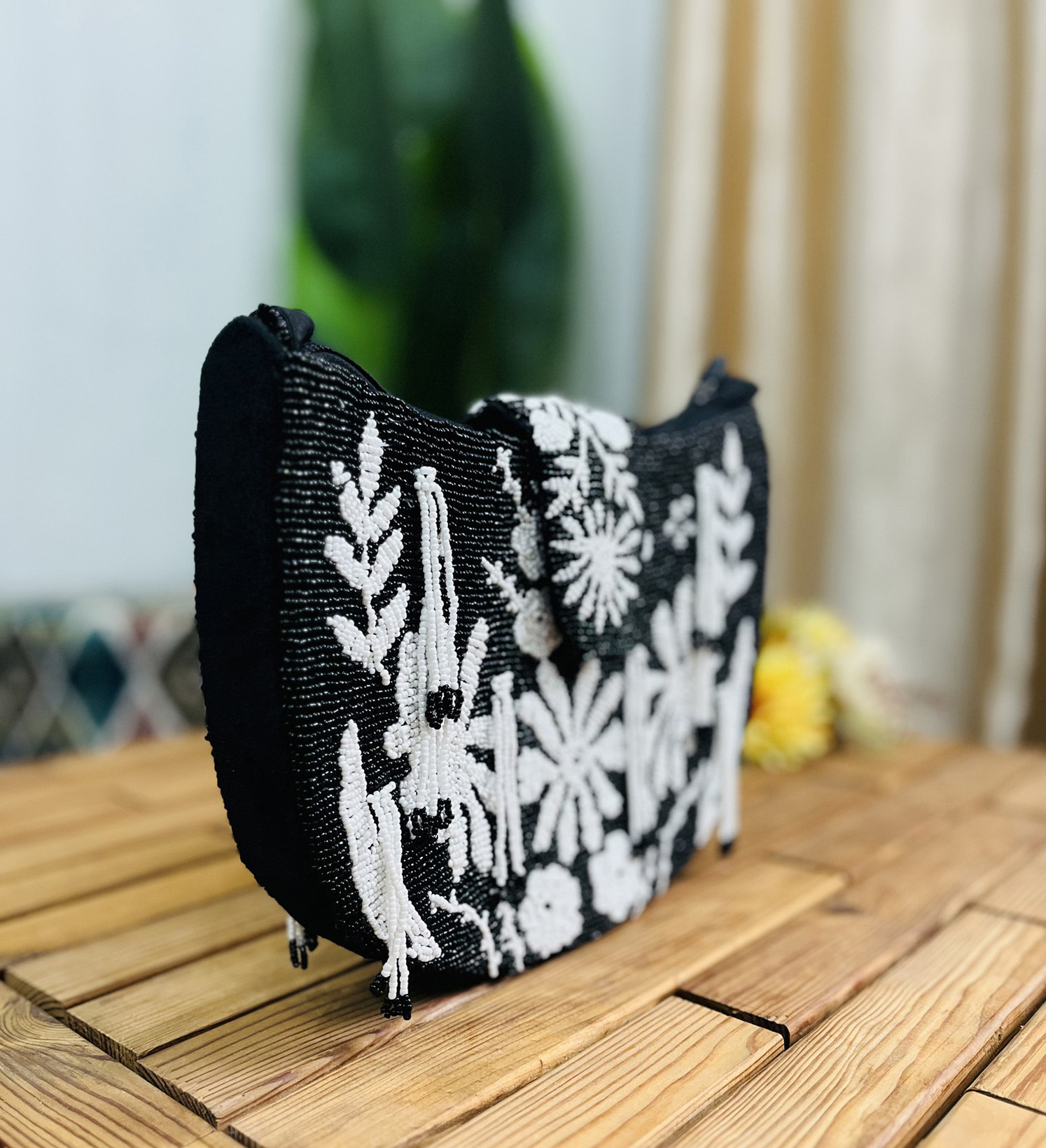 Monochrome floral hand-beaded shoulder bag with intricate pattern, featuring a single strap and elegant design.