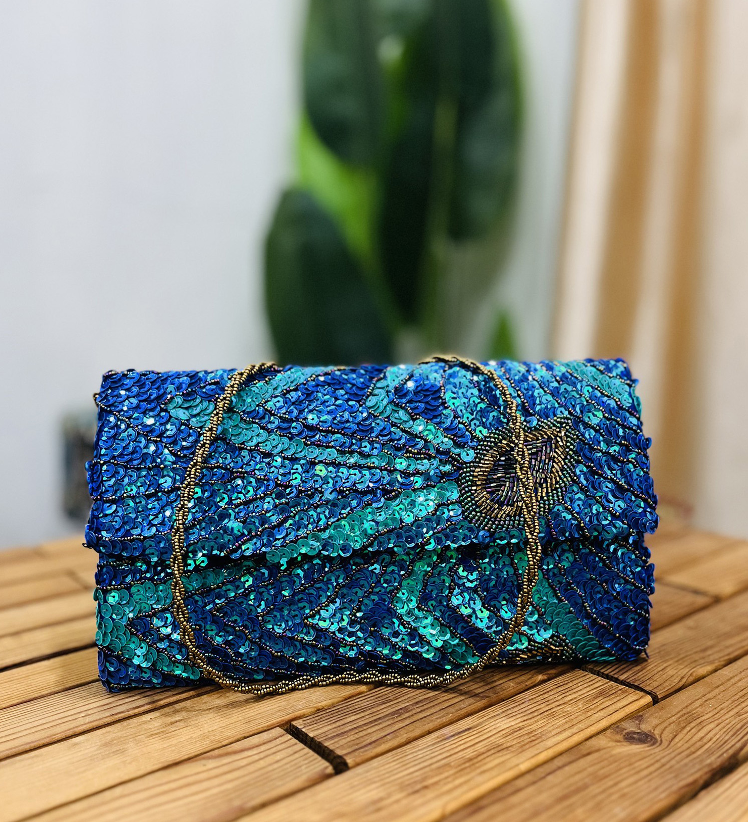 Handcrafted envelope clutch featuring a peacock feather design with sequins and beads, on a textured fabric by Zara Label.