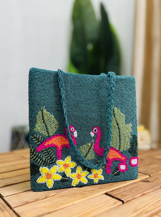 Hand-beaded tote bag with vibrant flamingo design, tropical patterns, and colorful beads against a light background.