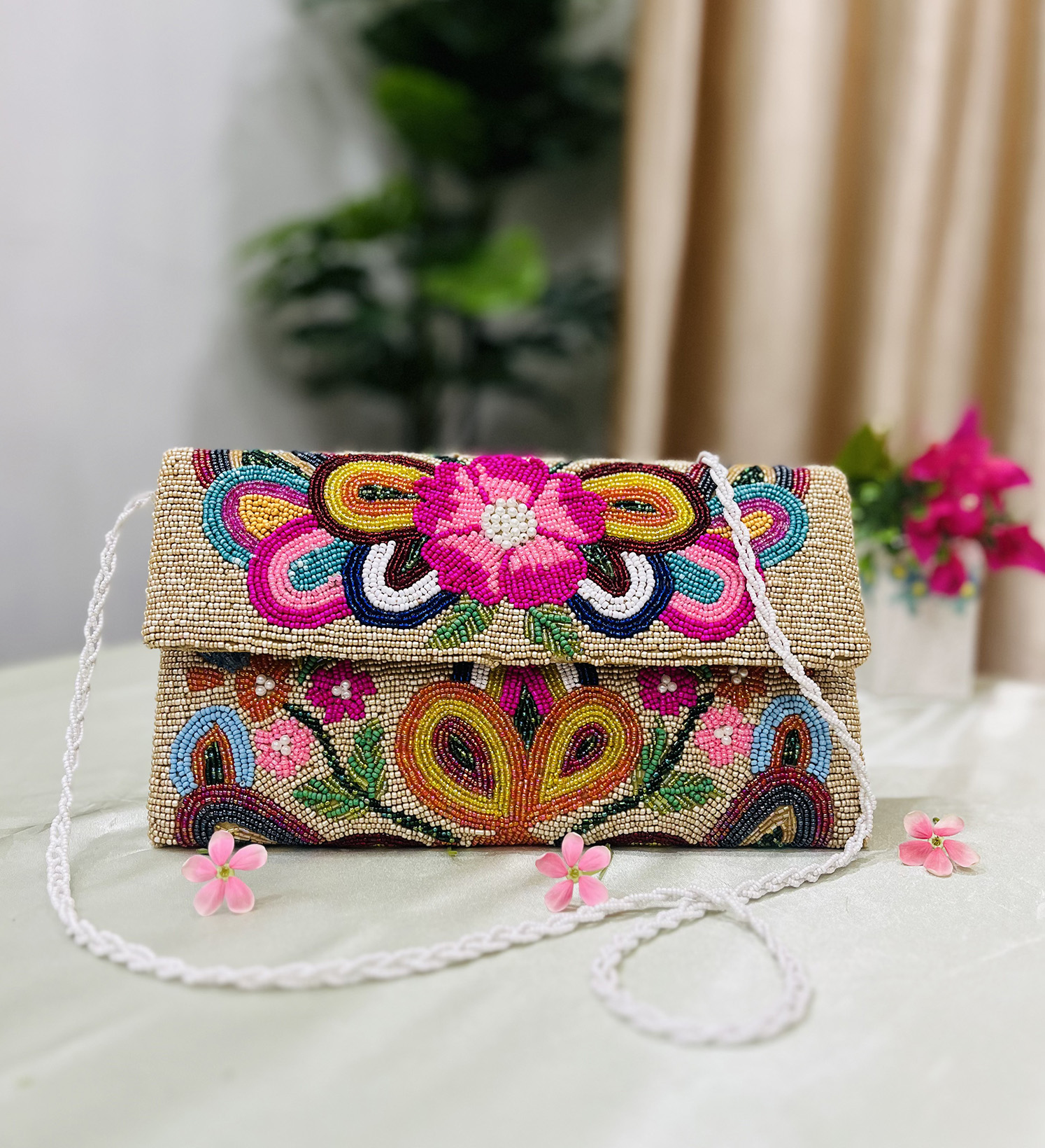 Hand-beaded envelope clutch with vibrant floral patterns, featuring intricate colorful beadwork by Zara Label on a black