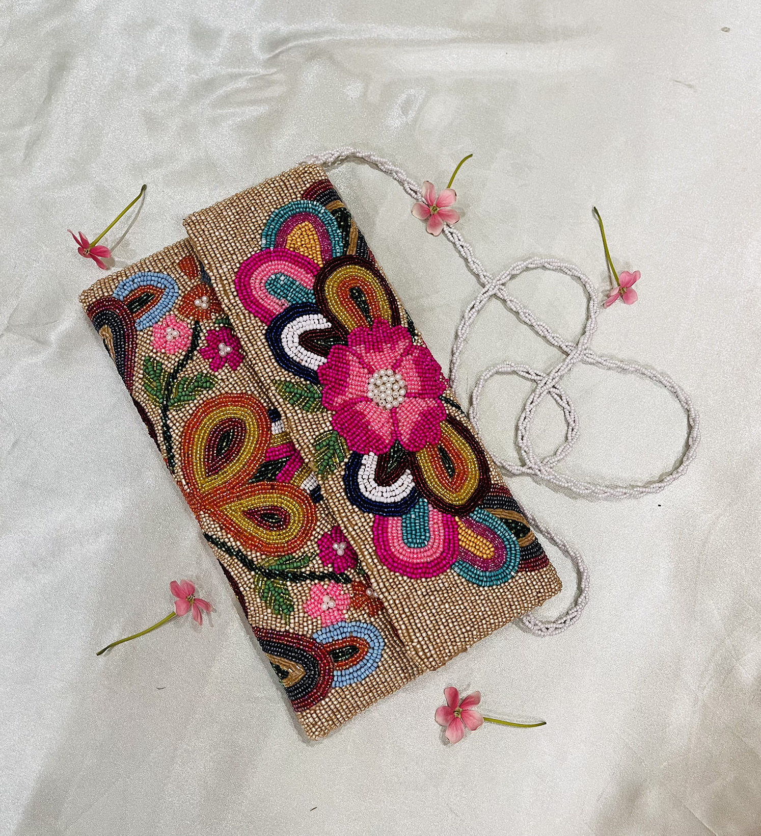 Colorful hand-beaded envelope clutch with floral patterns, from Zara Label, displayed against a neutral background.