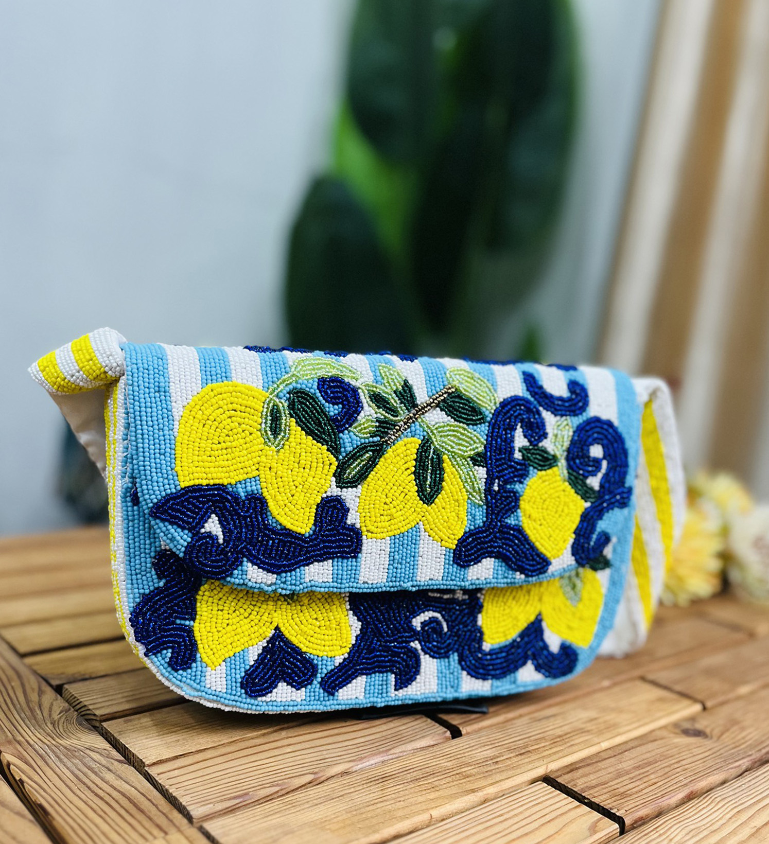 Small lemon-shaped shoulder bag with intricate hand-beaded details on a green strap, designed by Zara.